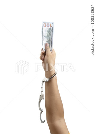 A human hand in handcuff holding money A human hand in handcuff holding money 108338624
