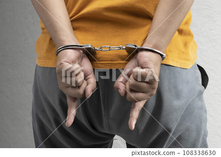 Arrested man with a handcuff on his hand Arrested man with a handcuff on his hand 108338630