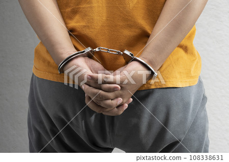 Arrested man with a handcuff on his hand Arrested man with a handcuff on his hand 108338631