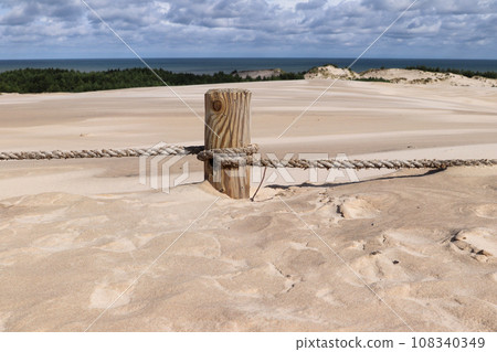 Pillar covered in sand on the hiking trail through the Lacka gora dune near Leba village in the Slovincian National Park 108340349