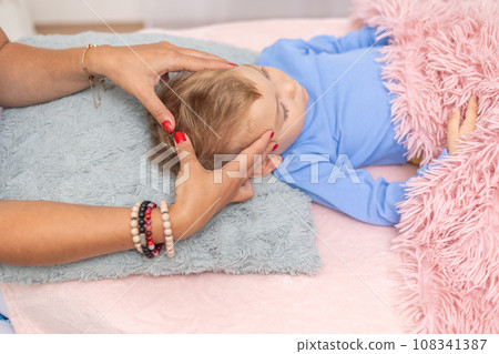 Woman healer performing access or consciousness bars to young boy, pseudoscientific method of alternative medicine that focuses on massaging various points on the head, an alternative medicine concept 108341387