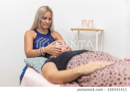 Woman healer performing and seeking access or consciousness bars to cure diseases or heal injuries by means other than conventional medical treatment, an alternative medicine 108341411