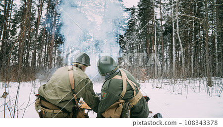 Back View On Re-enactors Dressed As American Infantry Soldiers Fire From Mortar. Usa Army Soldiers Of World War Ii. Mortar Shooting Explosions. Reconstruction Defense Battles. Heroes Of War 108343378