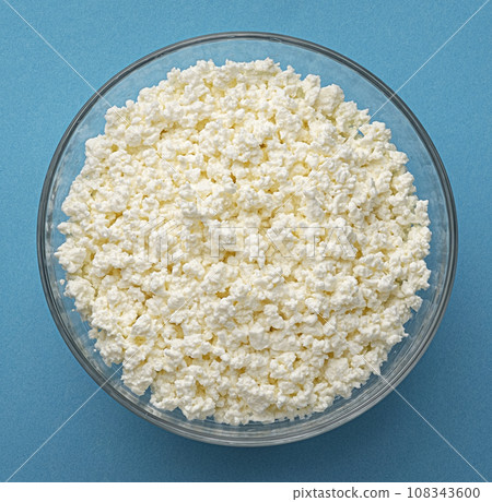 Bowl of cottage cheese on blue background, top view 108343600