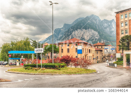 City intersection with scenic mountain in the background, Lecco, Italy 108344014