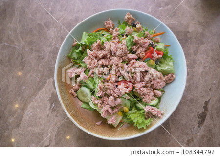 spoon pick tuna salad from a bowl on table spoon pick tuna salad from a bowl on table 108344792
