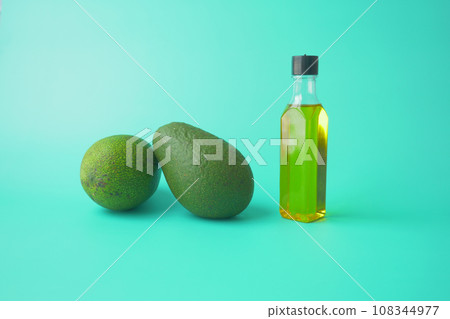 oil and slice of avocado on light green background oil and slice of avocado on light green background 108344977