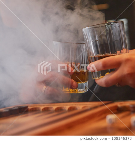 People drinking whiskey, smoking hookah and playing backgammon. 108346373