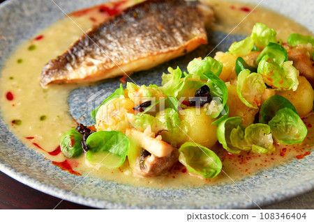 Grilled sea bass fillet served with vegetable garnish Grilled sea bass fillet served with vegetable garnish 108346404