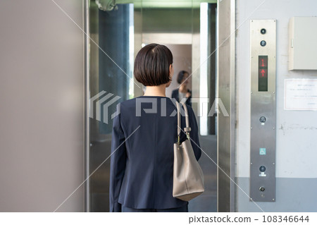 A woman riding an elevator A woman riding an elevator 108346644