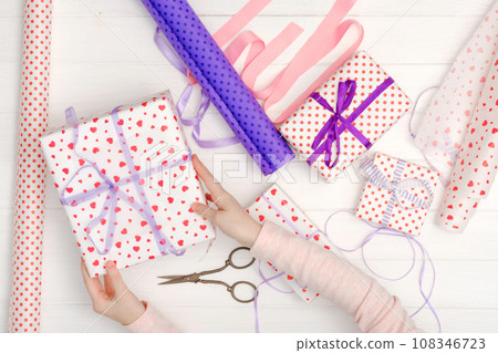 Girl tied ribbon on the gift Girl tied ribbon on the gift 108346723