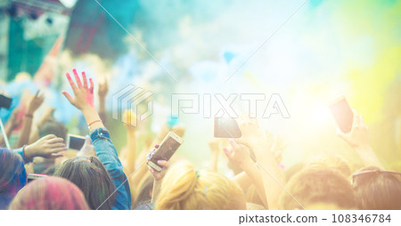 Crowd of people dancing and celebrating Holi festival of colors Crowd of people dancing and celebrating Holi festival of colors 108346784