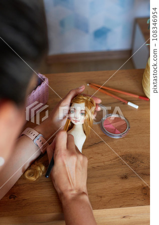 Creative woman painting handmade doll face. 108346954