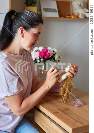 Creative woman painting handmade doll face. 108346955