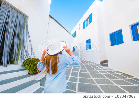 Little girl walking on a greek street Little girl walking on a greek street 108347062