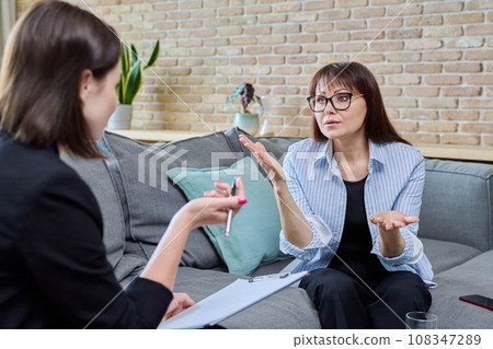 Middle-aged woman at meeting with psychologist, counselor Middle-aged woman at meeting with psychologist, counselor 108347289