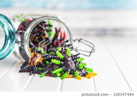 Scary sweet jelly spiders. Halloween candies on white table. 108347484
