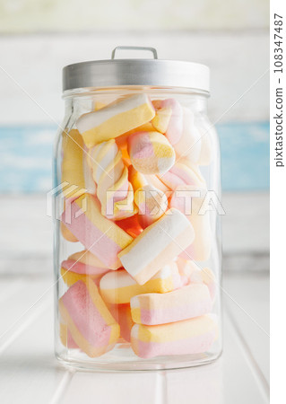 Sweet colorful marshmallows in jar on white kitchen table. 108347487