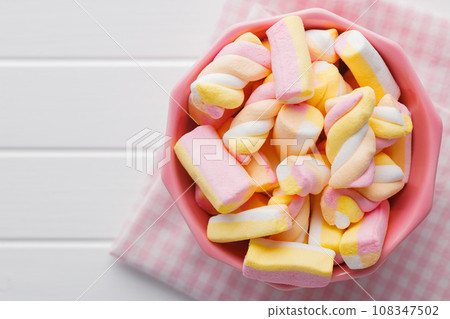 Sweet colorful marshmallows on white kitchen table. Sweet colorful marshmallows on white kitchen table. 108347502