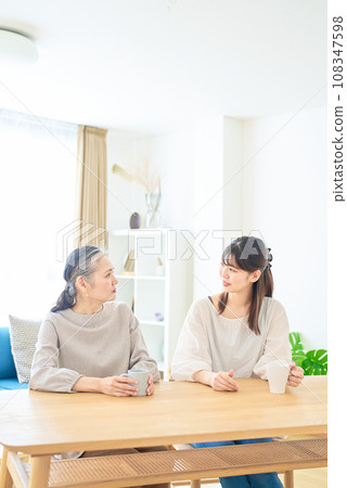 高級女性和年輕女性在房間裡友好交談 高級女性和年輕女性在房間裡友好交談 108347598