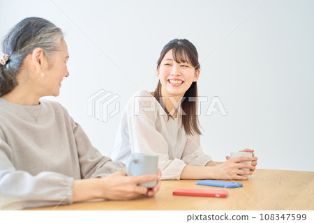 高級女性和年輕女性在房間裡友好交談 高級女性和年輕女性在房間裡友好交談 108347599