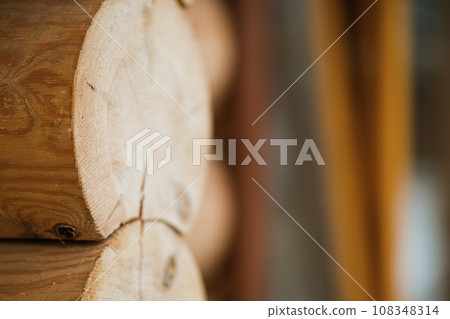 Natural background pattern of log wall. Construction of houses made of wood, rounded timber Natural background pattern of log wall. Construction of houses made of wood, rounded timber 108348314