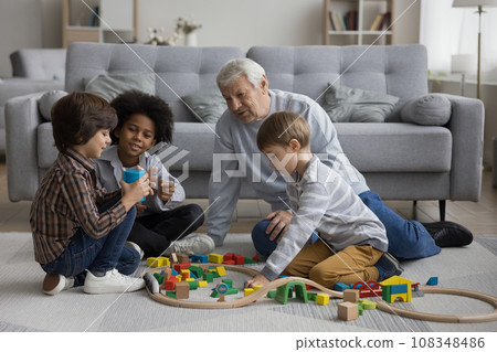 Multigenerational family play wooden railway at home Multigenerational family play wooden railway at home 108348486