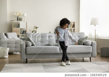 Pretty little African boy dancing in living room 108348529