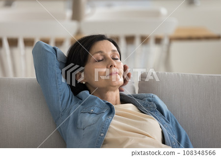 Mature female falling asleep on sofa at home Mature female falling asleep on sofa at home 108348566