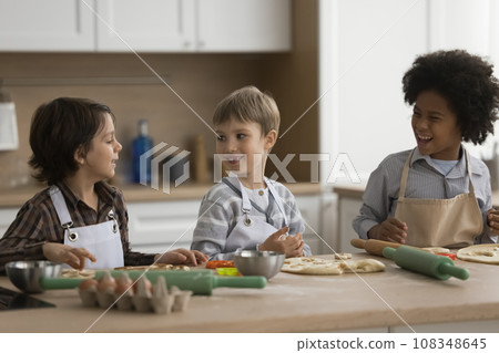 Children spend time in kitchen making dough Children spend time in kitchen making dough 108348645