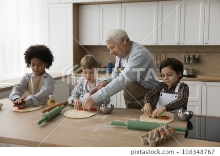 Loving great-grandpa teach to cook his little great-grandchildren Loving great-grandpa teach to cook his little great-grandchildren 108348767