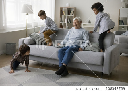 Older great-grandpa looking how their three cheerful great-grandchildren playing Older great-grandpa looking how their three cheerful great-grandchildren playing 108348769