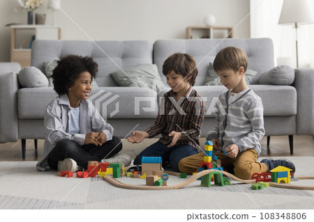 Three cute multiethnic boys play wooden railway at home 108348806