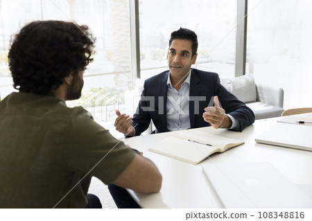 Successful Indian business man talking to male colleague, manager, employee Successful Indian business man talking to male colleague, manager, employee 108348816