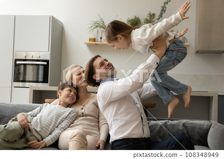 Joyful strong daddy holding little kid in arms Joyful strong daddy holding little kid in arms 108348949