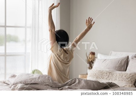 Rear view mature woman awakening in the morning in bedroom 108348985