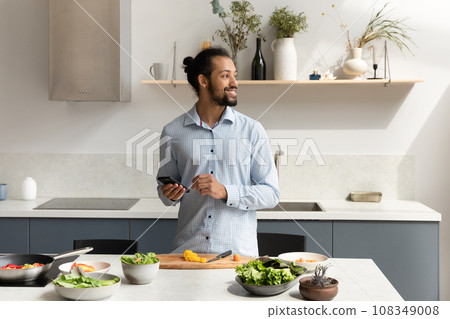 Happy chef guy using cellphone table with fresh organic vegetables Happy chef guy using cellphone table with fresh organic vegetables 108349008