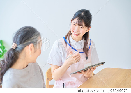 Senior woman and young woman in apron having a conversation Senior woman and young woman in apron having a conversation 108349071