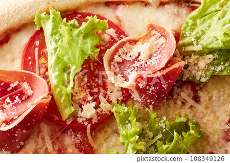 Pizza with prosciutto, lettuce salad and parmesan. 108349126