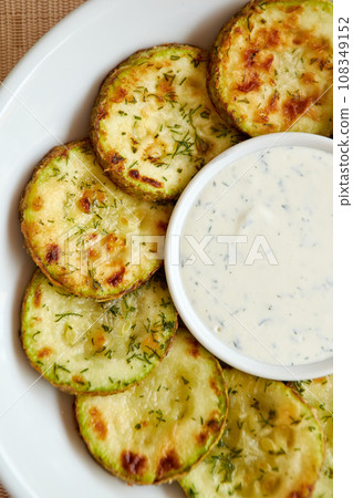 Fried sliced zucchini served with yogurt dip. 108349152