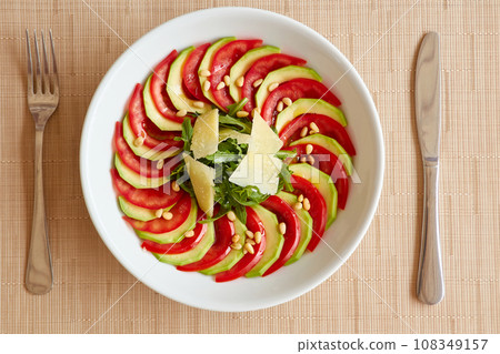 Dietary salad with zucchini, tomato, arugula and sliced parmesan. 108349157