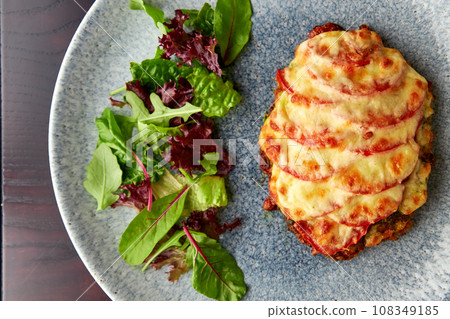 Tasty pork chop oven baked with tomatoes and cheese Tasty pork chop oven baked with tomatoes and cheese 108349185