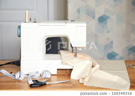 Sewing machine with piece of fabric on table. Sewing machine with piece of fabric on table. 108349358