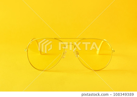 Yellow sunglasses on paper background, minimalism, monochrome. 108349389