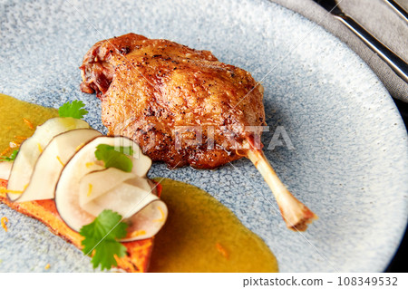 Duck leg with vegetable garnish of carrot and black radish. Duck leg with vegetable garnish of carrot and black radish. 108349532