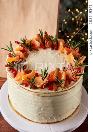 Festive Christmas cake decorated with fruits and rosemary. Festive Christmas cake decorated with fruits and rosemary. 108349541