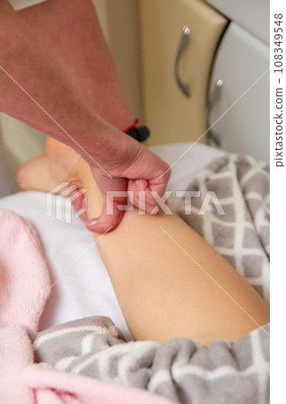 Therapist performing lymphatic drainage legs massage Therapist performing lymphatic drainage legs massage 108349548