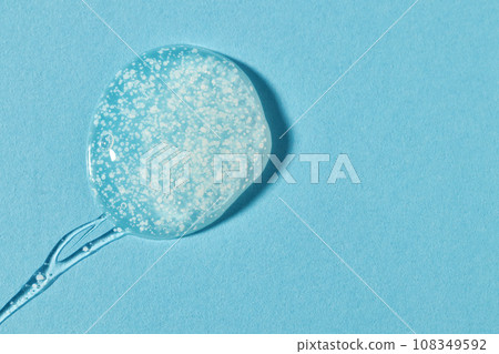 Smoothing scrub wash gel drop on blue background. 108349592