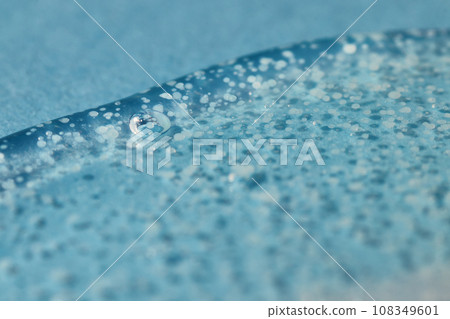 Texture of transparent gel with polishing beads on blue. 108349601