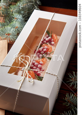 Festive Christmas meringue roll with cherries packed for present. Festive Christmas meringue roll with cherries packed for present. 108349604